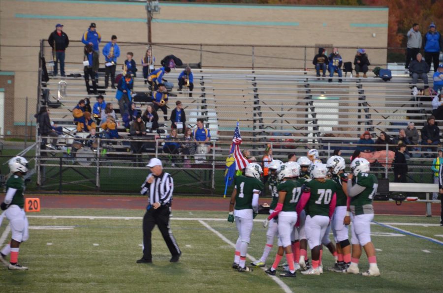 The football team huddles up as they attempt to extend their drive.