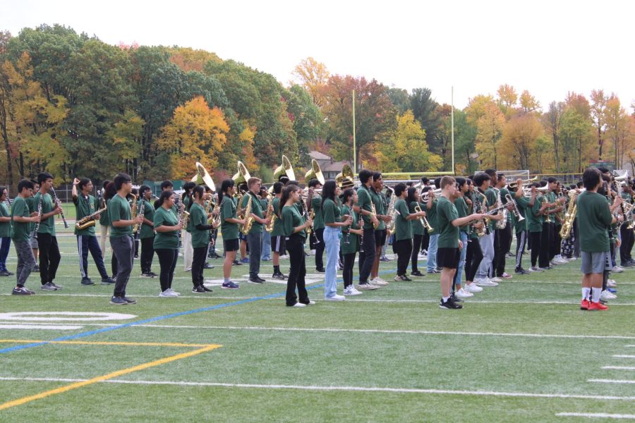 The JP Marching Band performs for the student body as students file into the football field bleachers.