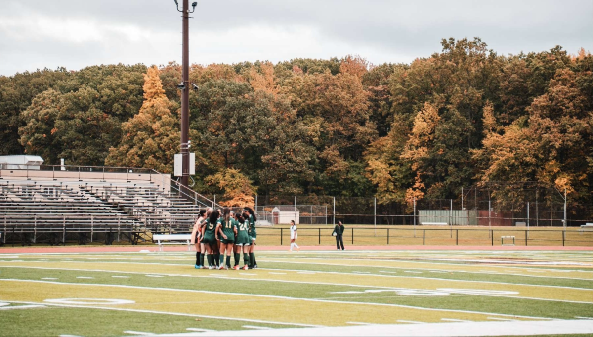 The varsity girls soccer team huddling.